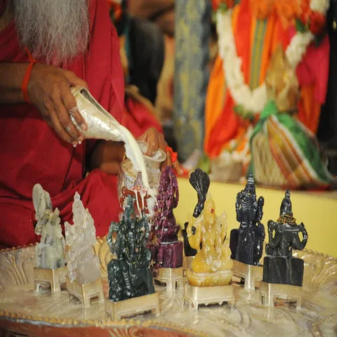 Priest performing abhishekam on the nine Navagraha murtis